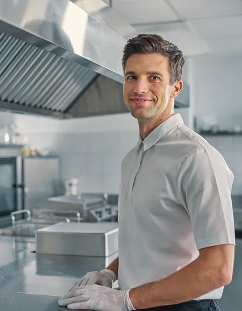 technician cleaning a commercial kitchen exhaust hood